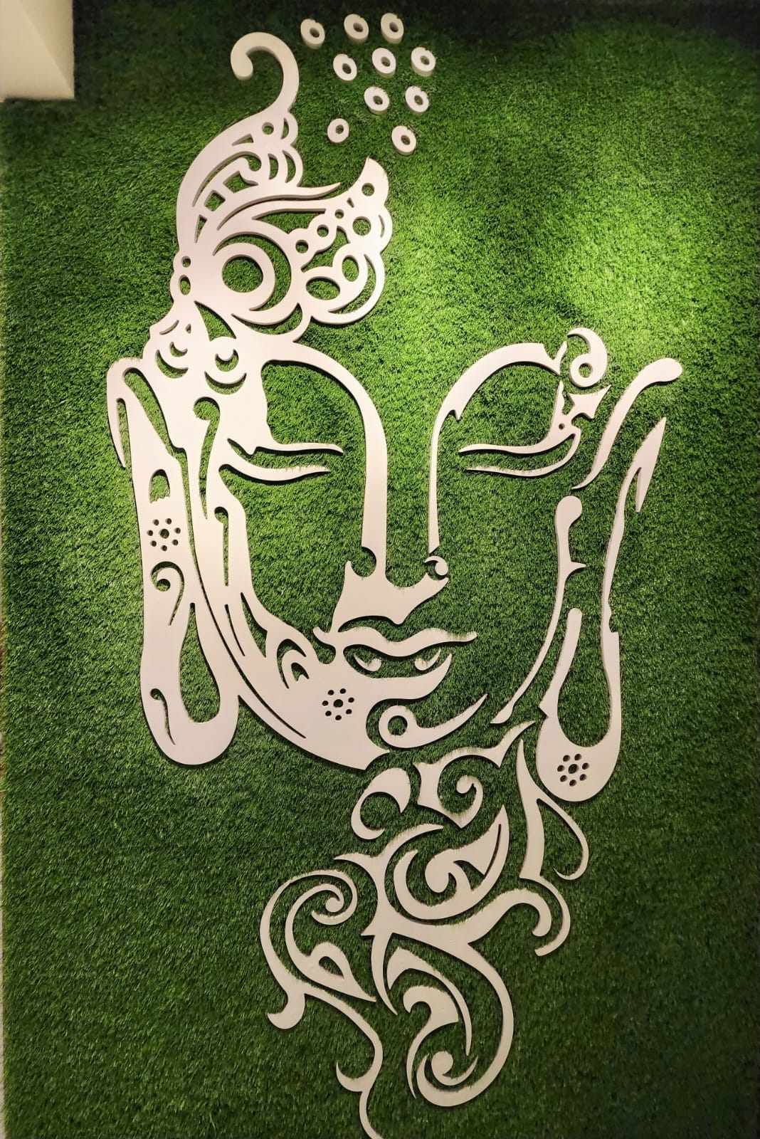 Buddha wall art on green turf backdrop in Vizag