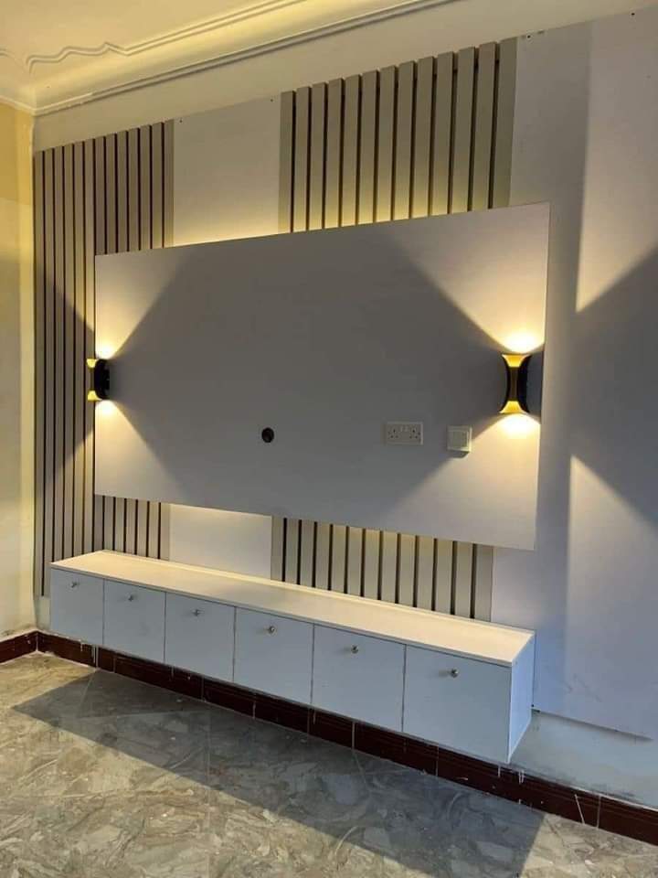 Minimal TV wall with vertical fluting and sconces in Vizag